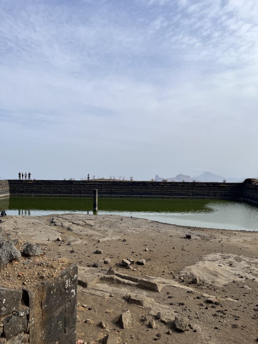 Gangasagar lake on Salher Fort in May, water low, held behind an old masonry retaining wall