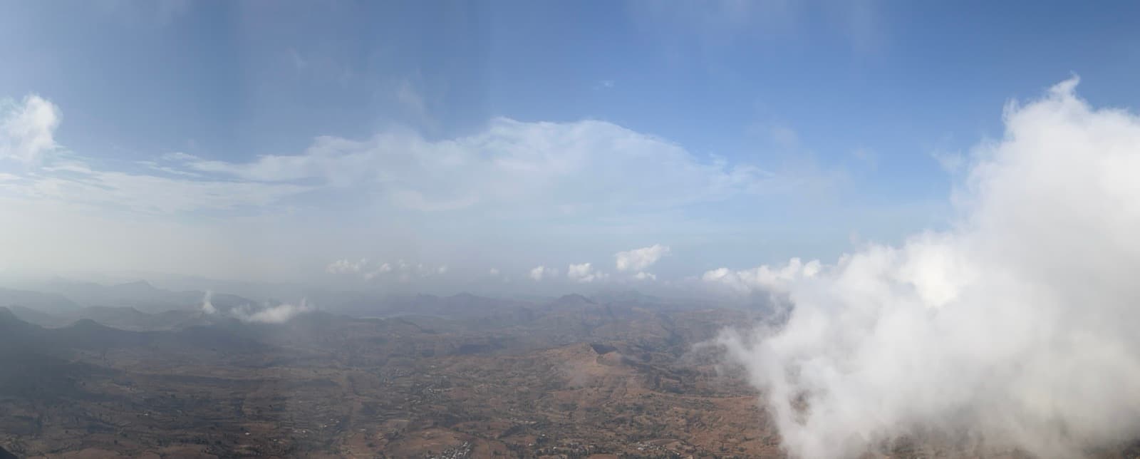 The view from the summit of Salher Fort at sunrise, with cloud sitting below the plateau and the Baglan valley stretching to the horizon