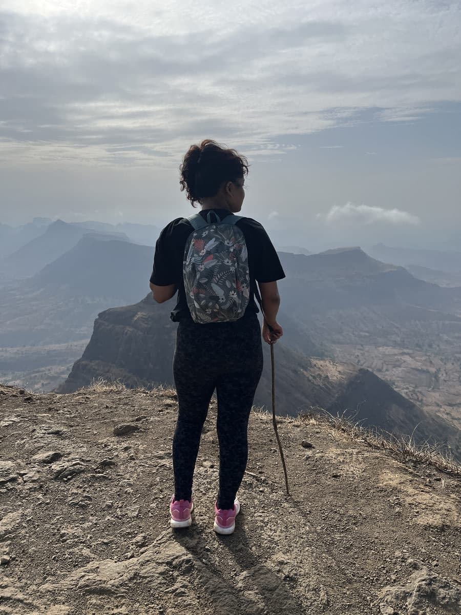 Sahil at the summit of Salher Fort with the valley and cloud behind